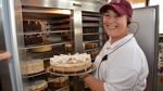 Savanna Wulf puts away a coffee and cream supreme cheesecake in one of the coolers